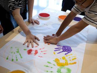 JICEFのアクティビティで、子どもたちが絵の具で手形を押し、創造性やつながり、多様性を表現している様子。