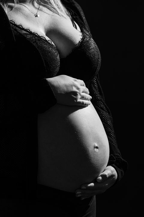 Babybauch mit schöner Lichtkante im Fotostudio, ästhetische Schwangerschaftsfotos in Berlin, emotionale Babybauchfotografie.