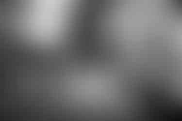 Kreatives Hochzeitsgruppenfoto: Brautpaar küsst sich vor dem historischen Gutshaus des KulturGut Wrechen, während die Gäste in Bewegungsunschärfe verschwimmen und eine besondere Dynamik erzeugen.