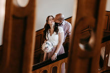 Das frisch verheiratete Brautpaar küsst sich im Treppenhaus vom Rathaus Treptow Berlin.