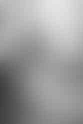 Braut steht vor dem Spiegel und betrachtet sich in ihrem eleganten Brautkleid.