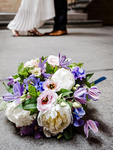 Brautstrauß auf Steinboden in der Station Berlin – im Hintergrund tanzendes Brautpaar | Spreekind-Fotografie