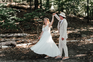 Brautpaar tanzt in der idyllischen Natur des KulturGut Wrechen – die Braut dreht sich an der Hand ihres Bräutigams, während ihr Brautkleid in seidigen, fließenden Bewegungen durch die Luft gleitet.