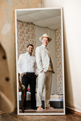 Vollständig vorbereitet: Der Bräutigam und sein Freund prüfen im Spiegel den Sitz des Anzugs.