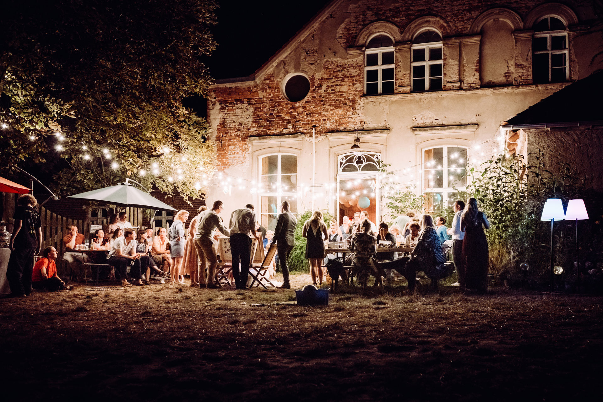 Die Party geht weiter mit lustigen Spielen und einer stimmungsvollen Beleuchtung, die das historische Gutshaus in ein warmes Licht taucht.