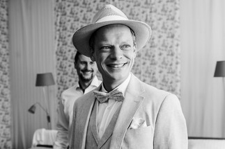 Der Bräutigam und sein Freund prüfen den finalen Look vor dem Spiegel, das Outfit sitzt perfekt.