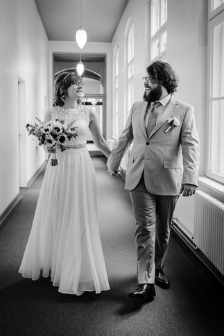 Frisch verheiratetes Brautpaar geht durch den Flur im Standesamt Neukölln – Hochzeitsfotograf Berlin, Spreekind-Fotografie