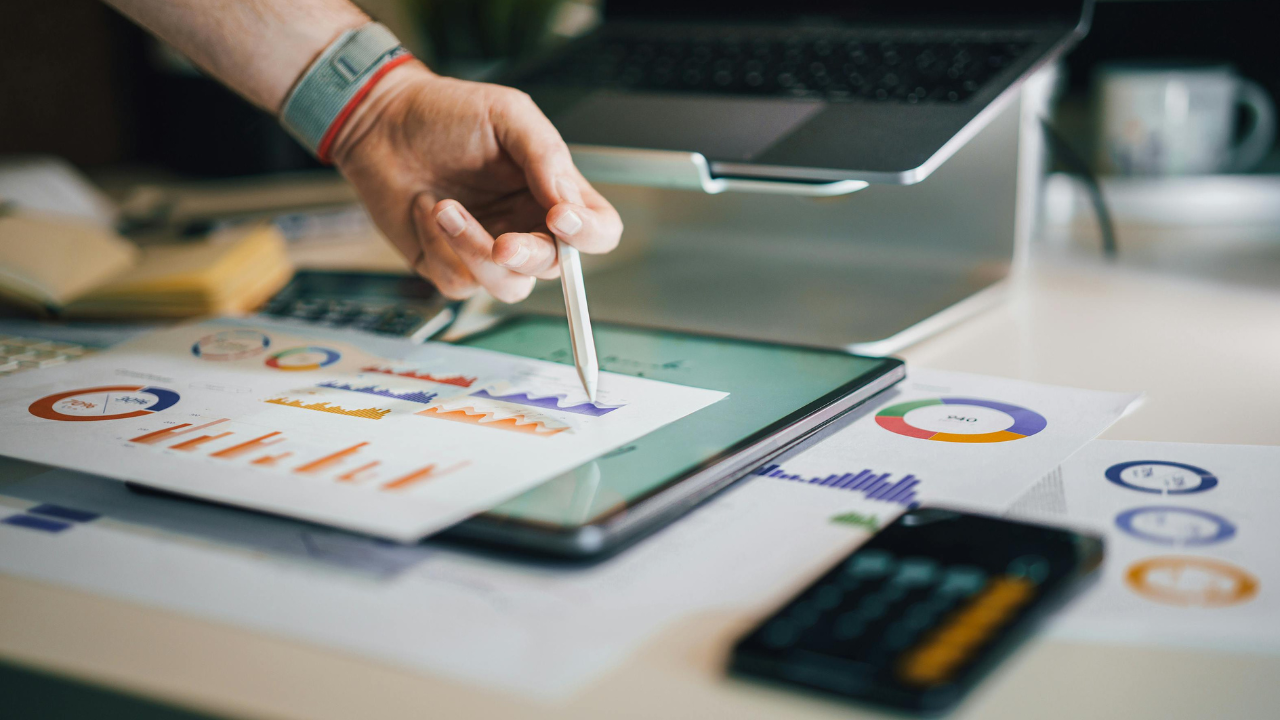 A person analyzing colorful charts and data on a tablet, symbolizing explainable AI through transparent performance metrics and actionable insights.