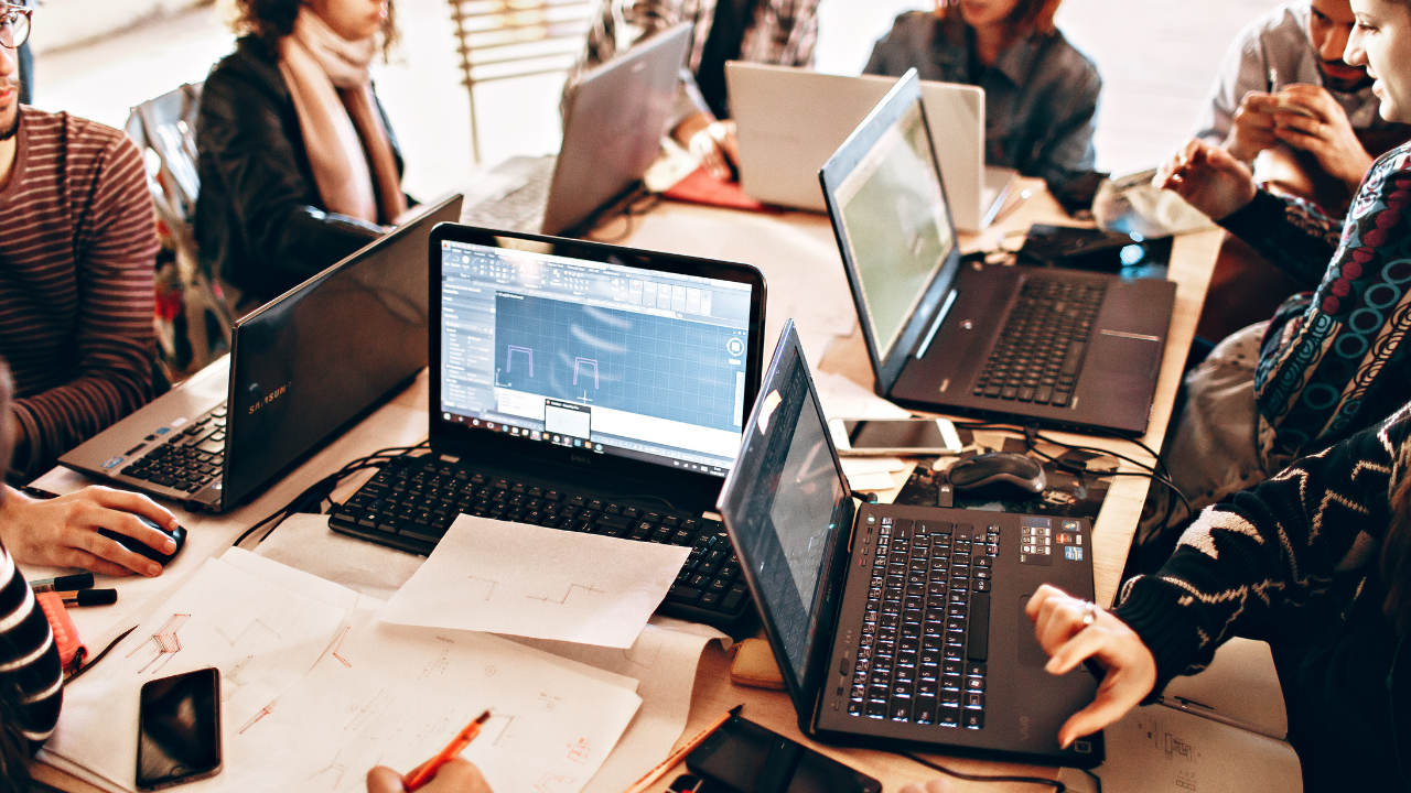 Team using laptops and papers for business automation with AI collaboration.