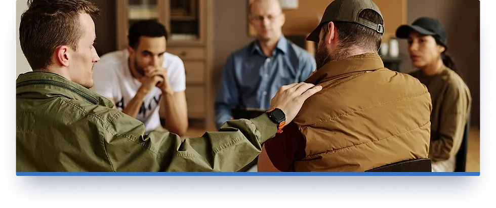 A group of patriots sit in a circle, comforting a man who expresses his traumatic experience