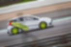 White rally car with yellow wheels on a track