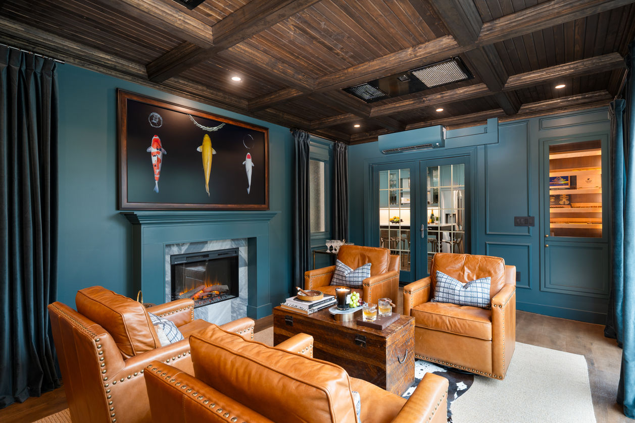 Custom cigar lounge with built‑in humidor by French doors, teal cabinetry, and brass mesh accents designed by Alexa Stellern Design in Lake St. Louis MO.