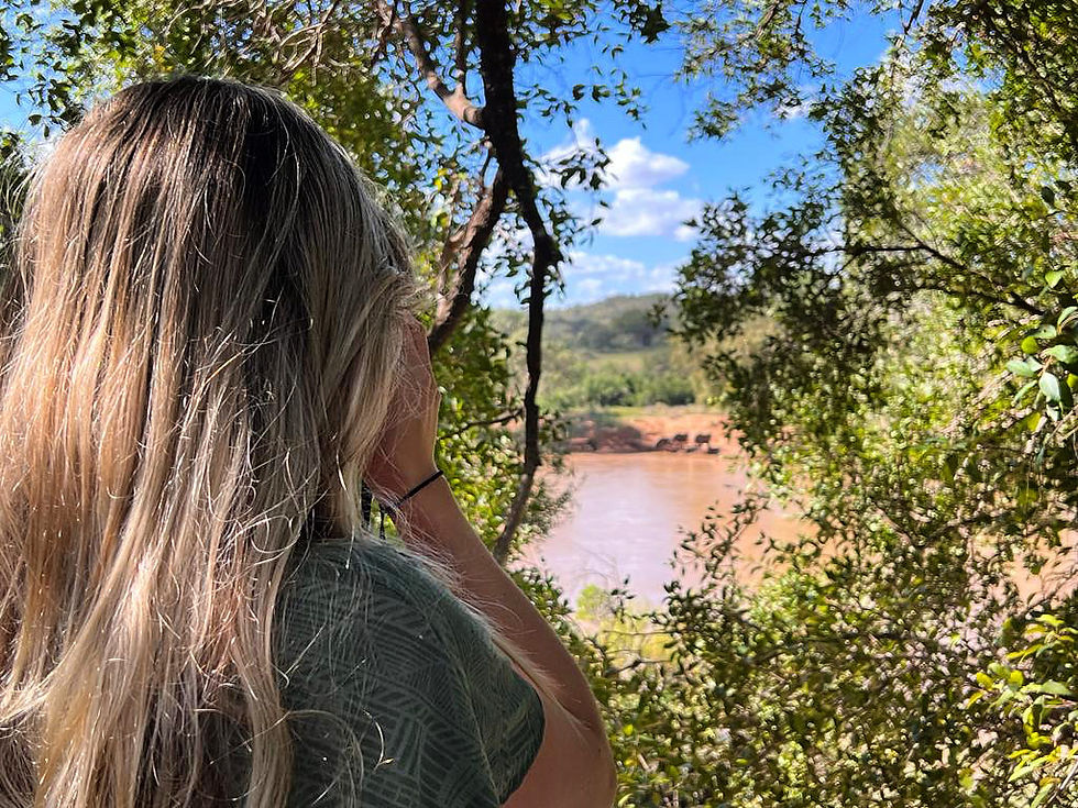 A girl watching a family of elephants through binoculars