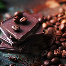 Stack of chocolate chunks with coffee beans on a wooden background, closeup_.jpg