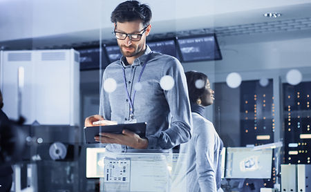 A man looking at a laptop in an IT environment