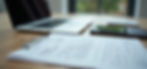 High angle view of certification documents and a laptop on a desk