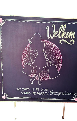 Welkom bord met vrouwensilhouet en tekst: 'Dit bord is te huur, vraag er naar bij Verzengde Zonnes'