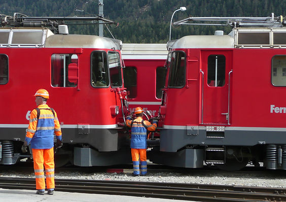 Zwei Eisenbahner der Rhätischen Bahn beim Kuppeln von Lokomotiven in Samedann