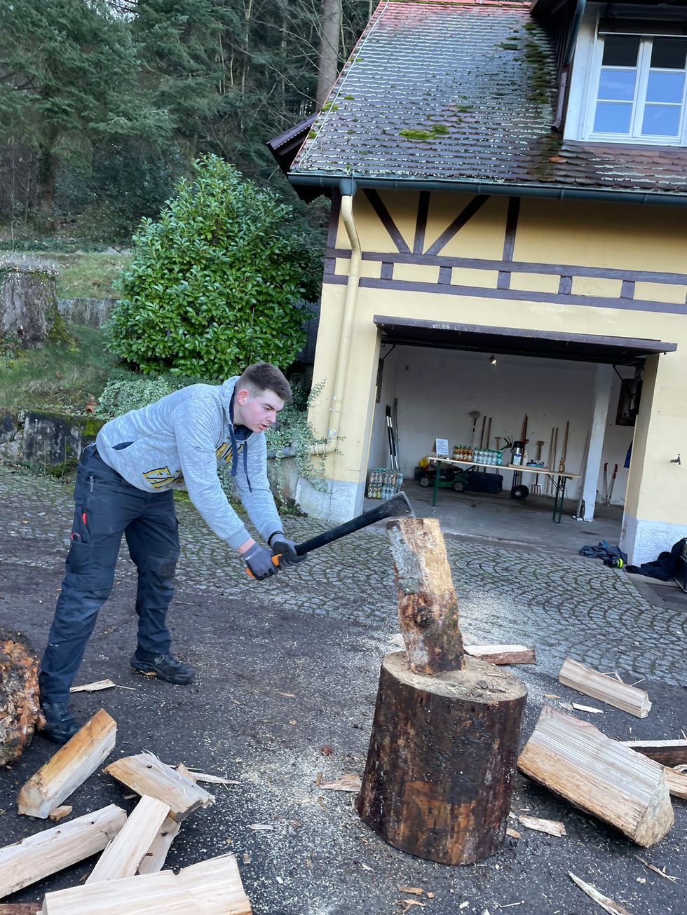 Mitarbeiter der Drogenhilfe Weitblick nutzt Holzspalter zur Brennholzproduktion. Effiziente Verarbeitung von Rohstoffen.