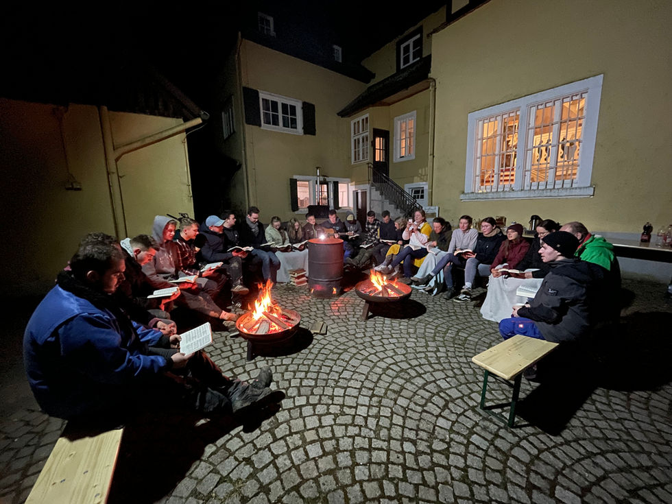 Mitarbeiter der Gefährdetenhilfe Weitblick stapelt gespaltenes Holz auf. Ordnung und Struktur bei der Lagerung von Brennholz.