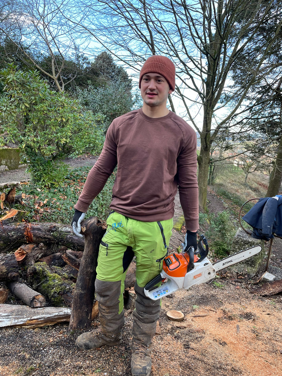 Mitarbeiter der sozialen Einrichtung stapelt Holz auf. Ordnung und Sorgfalt bei der Vorbereitung auf den Winter.