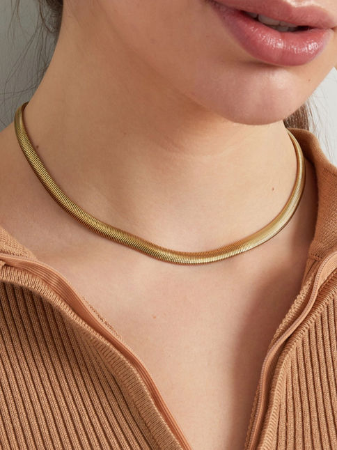 Die Gloria Halskette in Gold am Hals getragen zu einem braunen Oberteil – luxuriöser Liquid-Gold-Look für den Alltag.