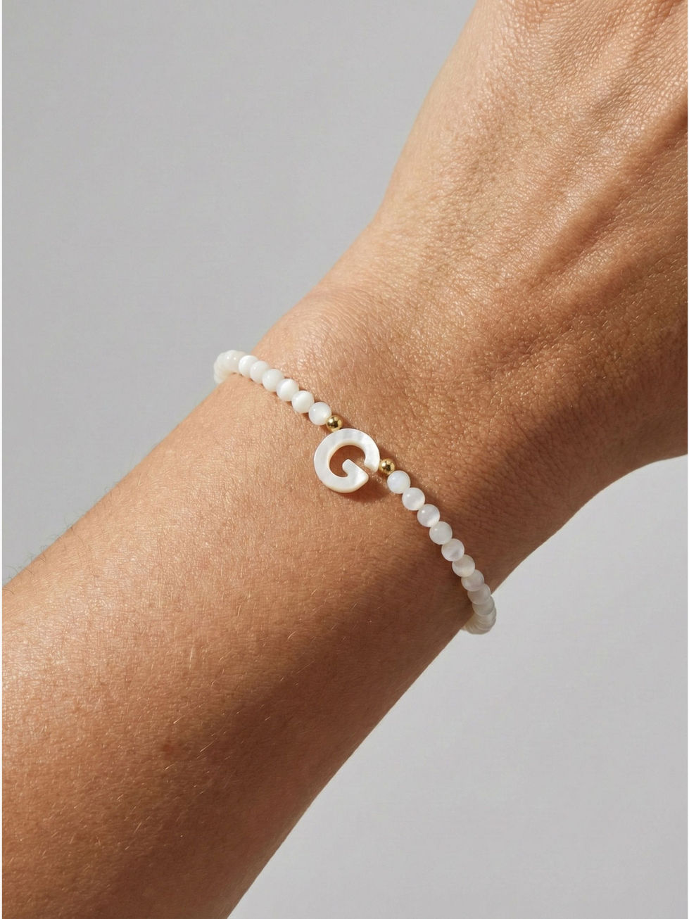 Personalisiertes Nova Initialen-Armband in Gold am Handgelenk getragen – eleganter Schmuck-Trend 2026.