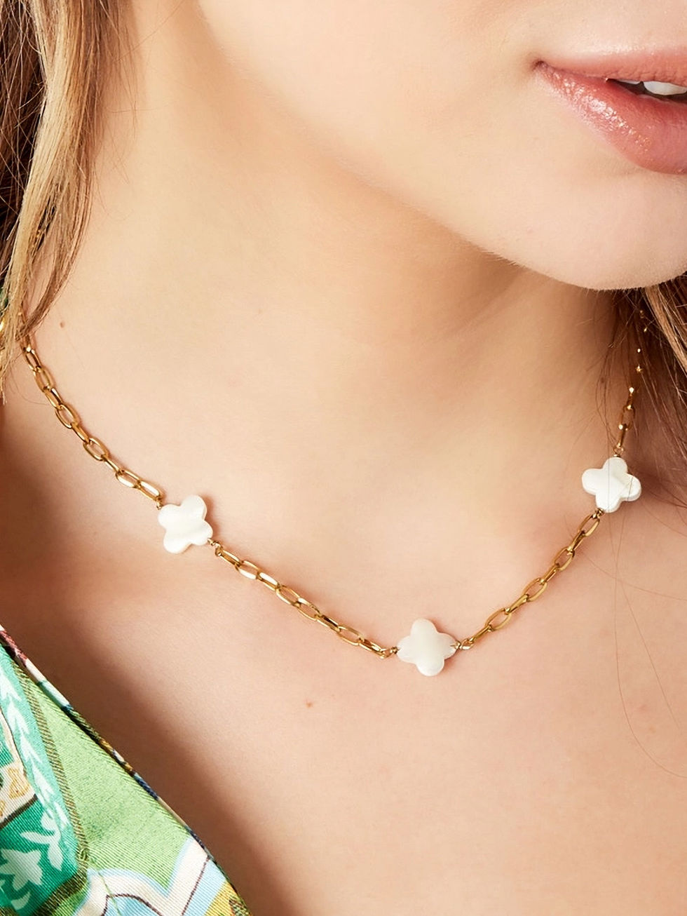 Die Arabella Halskette in Gold getragen – Elegantes Paperclip-Design mit schimmernden Perlmutt-Glücksbringern.
