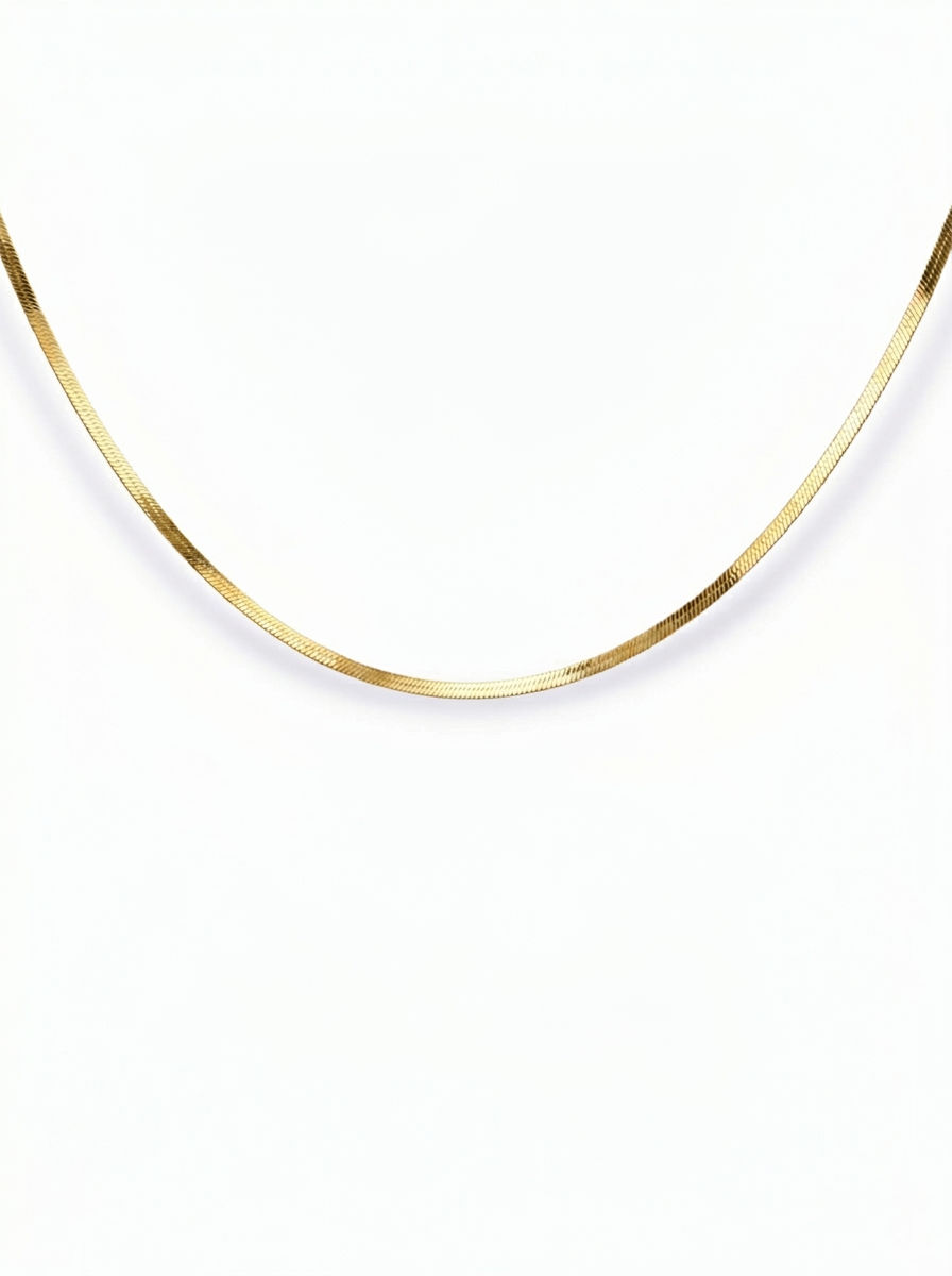 Feine goldene Schlangenkette mit glänzender Oberfläche auf weißem Hintergrund
