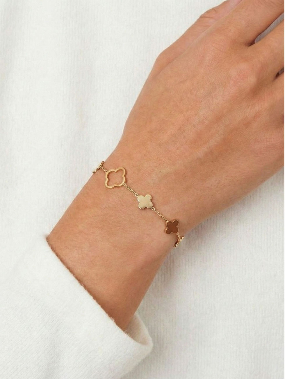 Elara Armband in Gold am Handgelenk getragen – Filigranes Kleeblatt-Design aus wasserfestem Edelstahl.