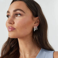 Eine stilvolle Frau trägt den eleganten, silberfarbenen Schmuck von SABIBEL.