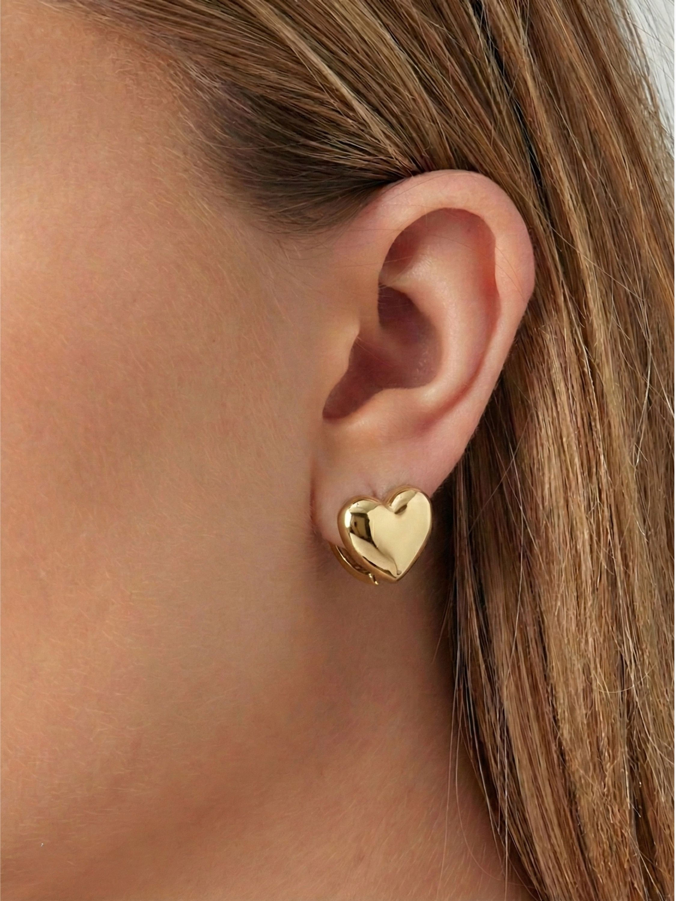 Model trägt die goldene glatte Seite der Sofia Herz-Hoops – zeitloser Chic für jeden Tag.