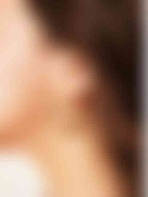 Detailansicht der goldenen Lauren Twist-Hoops am Ohr getragen – modernes Spiral-Design für elegante Akzente.
