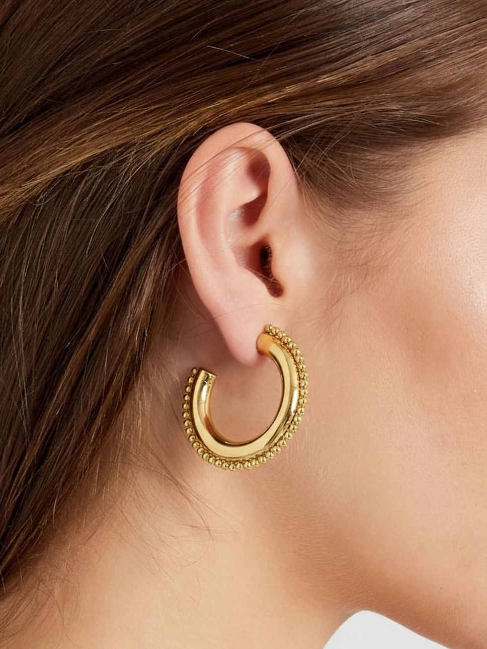 Detailansicht der goldenen Velora Perlen-Creolen am Ohr getragen – elegantes, großformatiges Design für einen luxuriösen Look