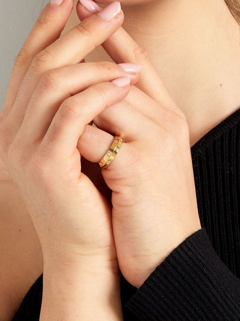 Casie Ring in Gold am Finger getragen – eleganter Edelstahl-Bandring mit Steinen für einen modernen Layering-Look