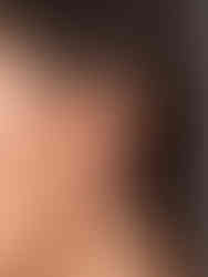 Detailansicht der goldenen Lunaris Ohrringe am Ohr getragen – modernes Kleeblatt-Statement in Größe M neben der Größe S.