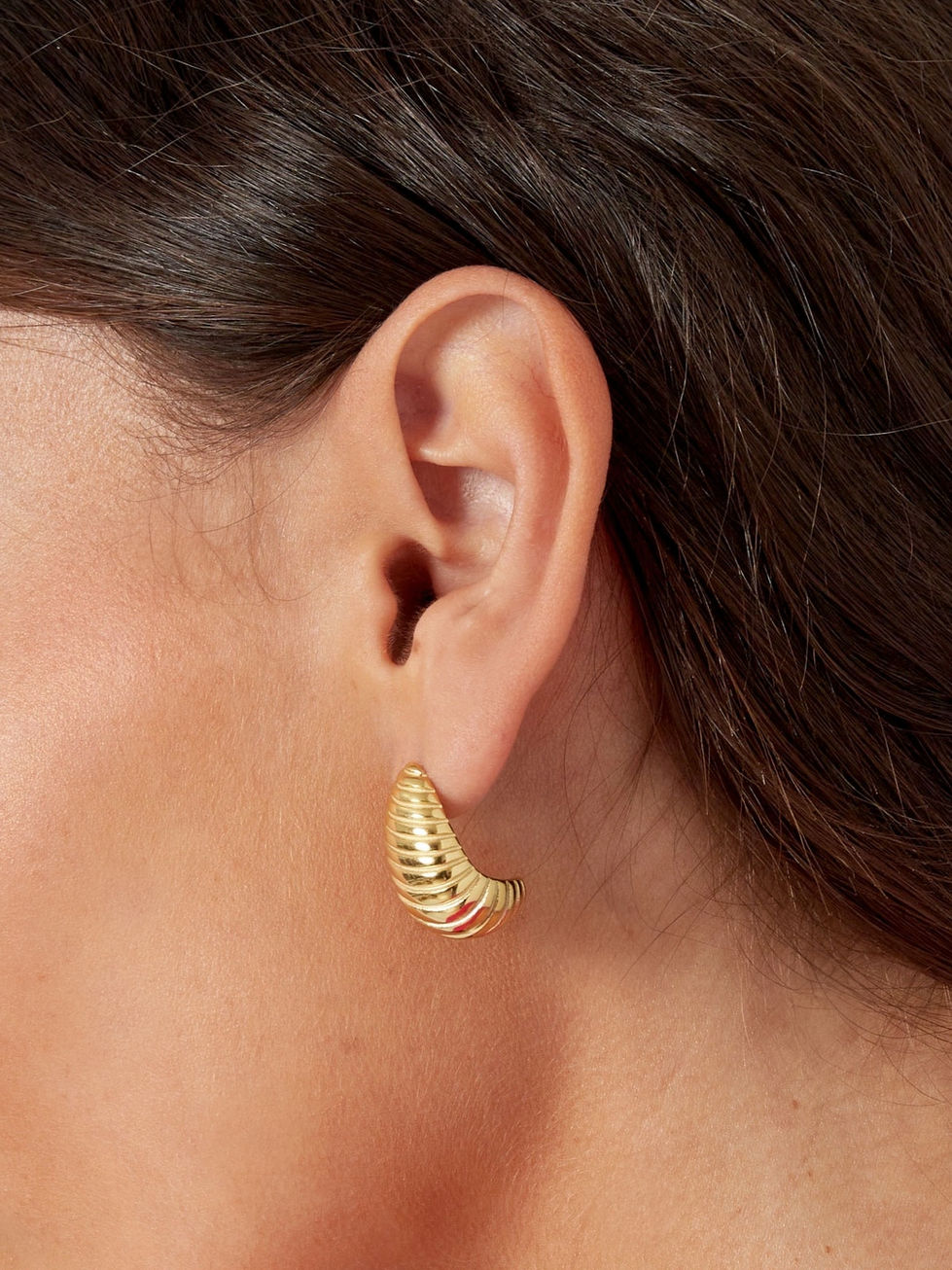 Detailansicht der goldenen Zariah Tropfenohrringe am Ohr getragen – modernes, geriffeltes Design für elegante Looks.