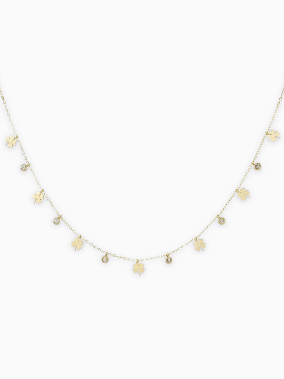 Goldene Nivara Halskette aus Edelstahl mit kleinen Kleeblatt-Anhängern und funkelnden Strasssteinen auf weißem Grund.