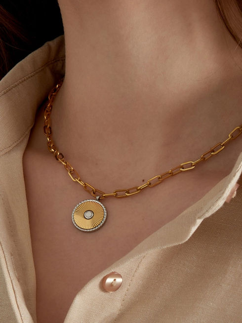Detailansicht der Sutton Halskette in Gold am Dekolleté – Elegante Gliederkette mit Muschel-Anhänger zu beiger Kleidung.