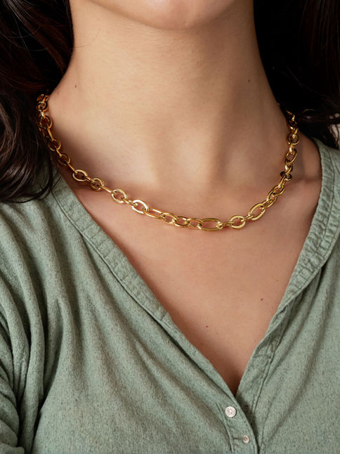 Fiona Halskette in Gold am Hals getragen zu einem grünen Oberteil – Klassischer Schmuck-Look.