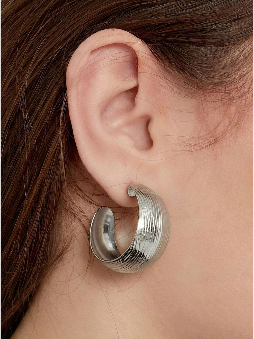 Die silberne Variante der Sylvaris Creolen am Ohr – zeitloser, architektonischer Edelstahlschmuck für stilsichere Auftritte.