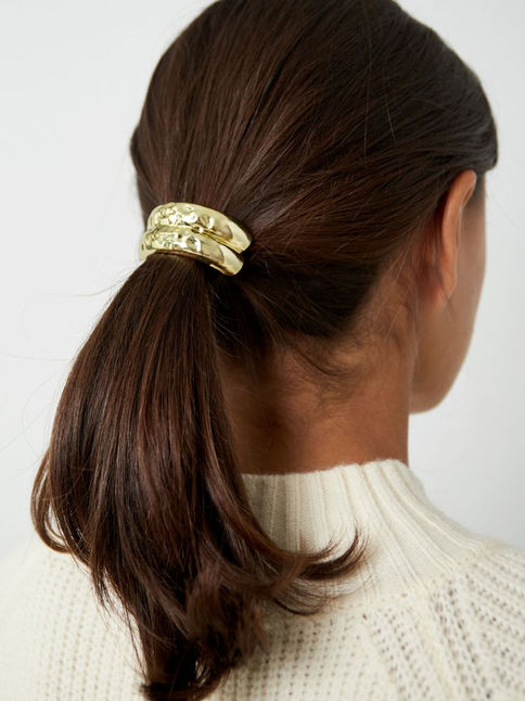Modell trägt Celora Hair Cuff in Gold mit strukturierter Oberfläche
