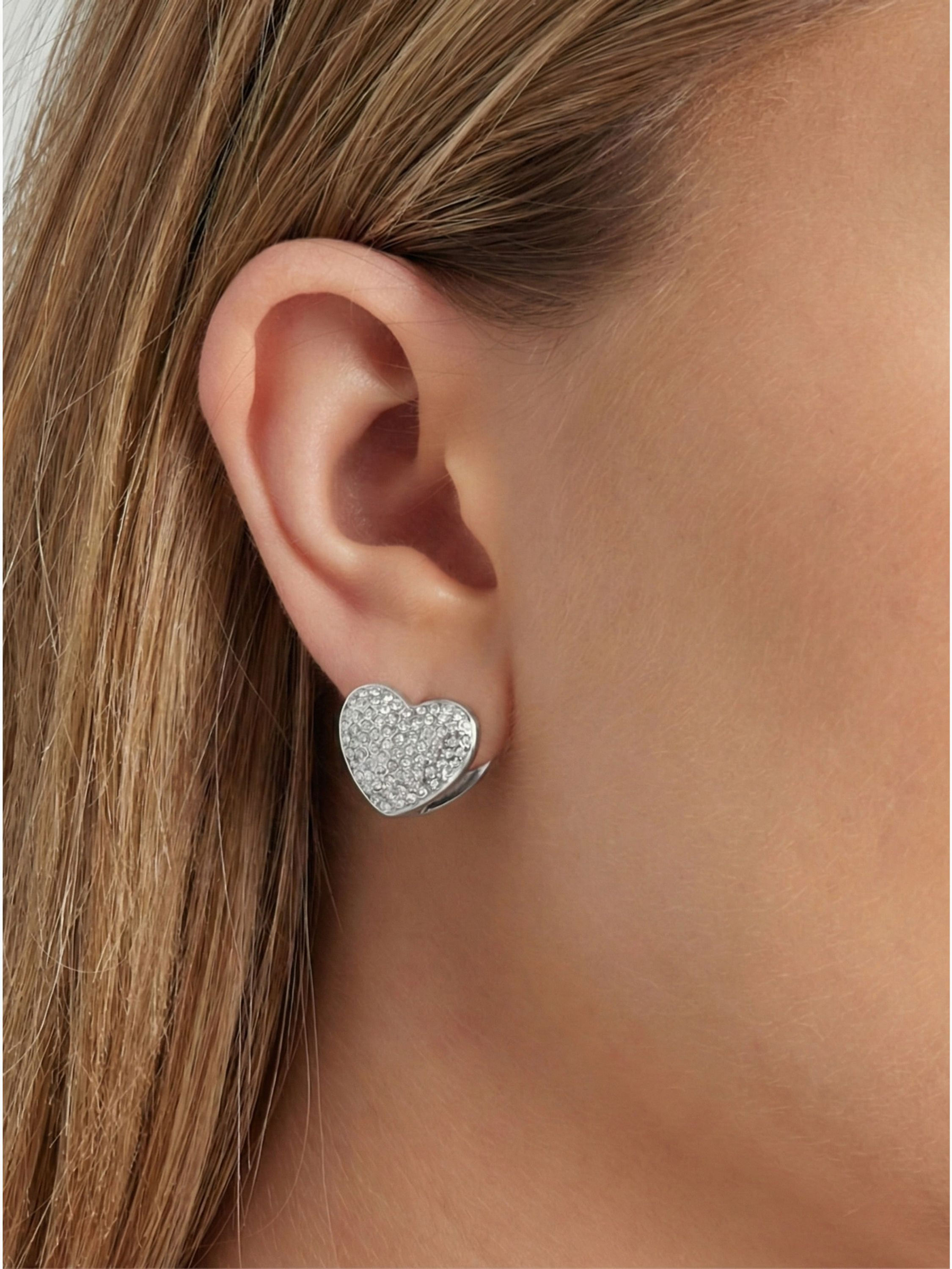 Silberne Sofia Herz-Ohrringe am Ohr – brillantes Lichtspiel durch das dichte Strass-Pavé.