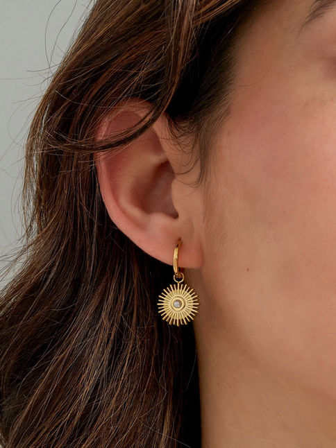 Detailansicht der Solera Sonnen-Ohrringe am Ohr getragen – filigraner, goldener Schmuck mit maritimem und himmlischem Vibe.