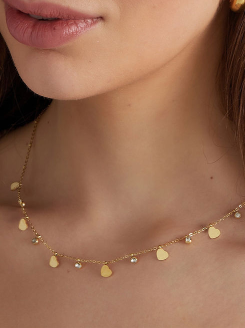 Detailansicht der Mira Luna Halskette in Gold am Dekolleté getragen – eleganter Herzschmuck aus wasserfestem Edelstahl.