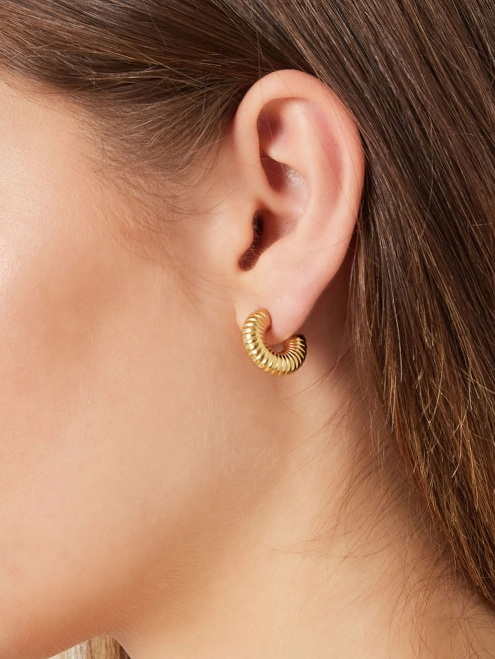 Cira Ohrringe am Ohr getragen – zeigt die perfekte Größe und die elegante Struktur der goldenen Creolen.