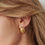 Miniaturbild: Nahaufnahme des Niara Muschel Ohrrings in Gold