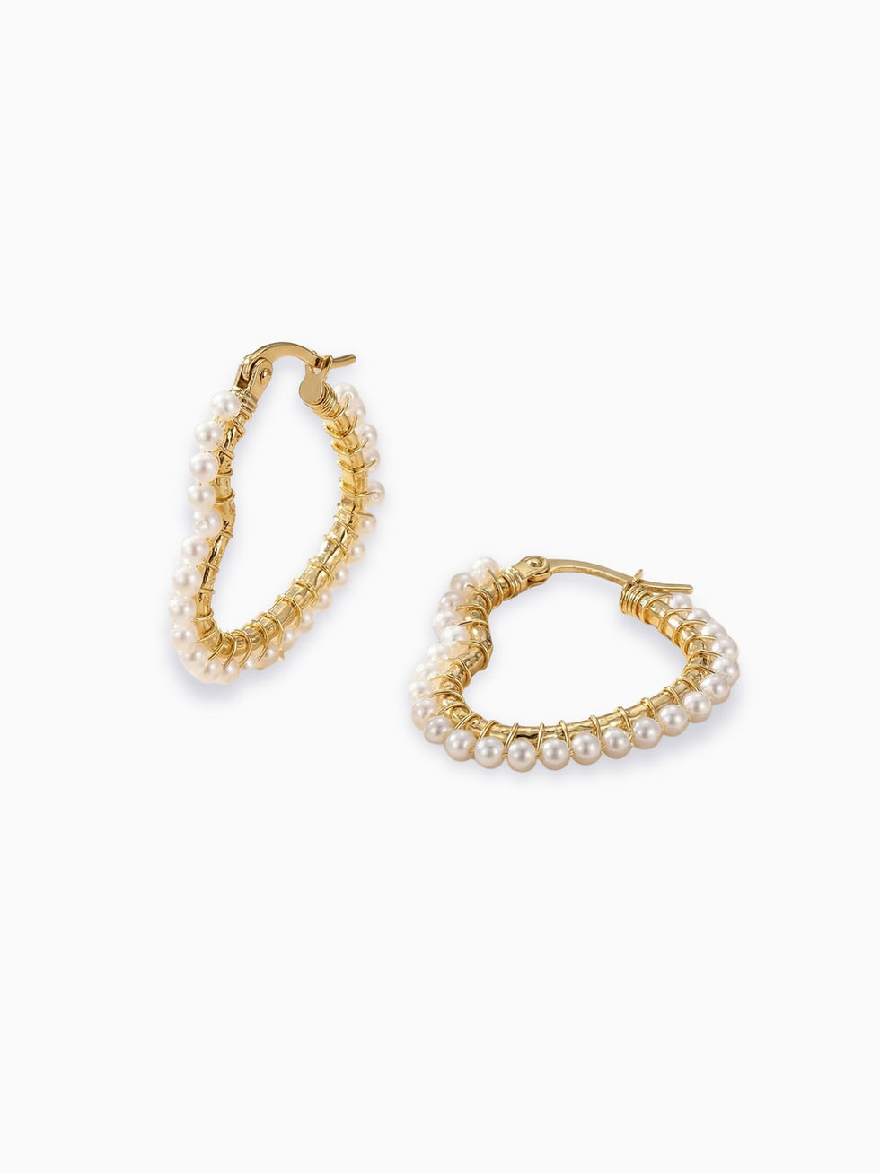 Goldene Piorella Herz-Ohrringe aus Edelstahl – Creolen in Herzform mit filigran aufgewickelten weißen Perlen auf weißem Grund