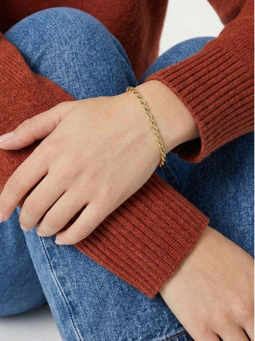 Nana Kordelarmband in Gold am Handgelenk getragen – Minimalistischer Edelstahlschmuck zu einem herbstlichen Look.