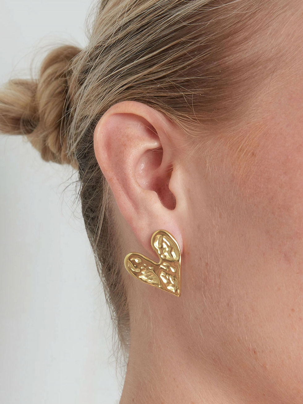 Nahaufnahme der Seloria Ohrstecker in Herzform in Gold.